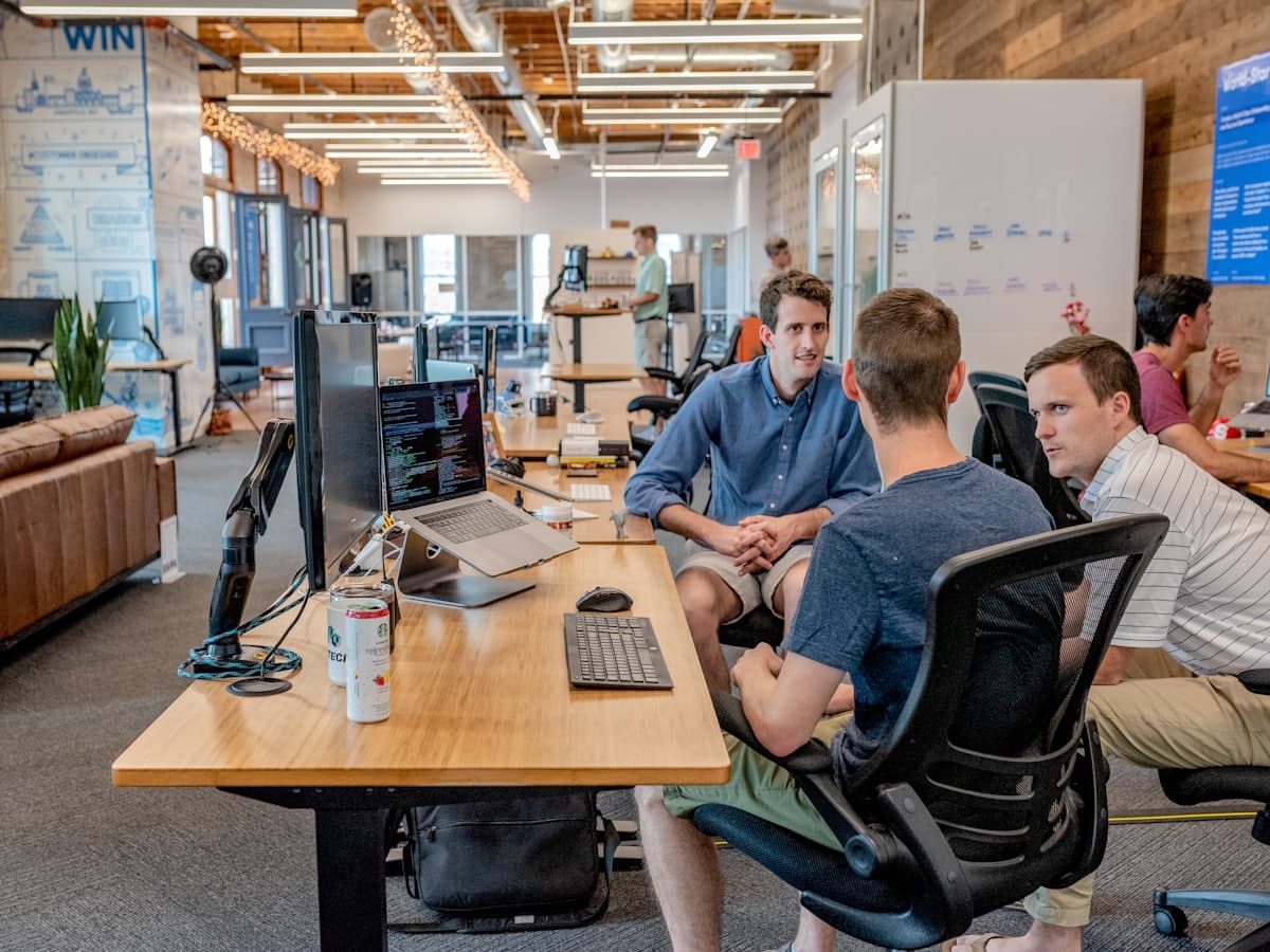 Three people working side by side at a row of desks
